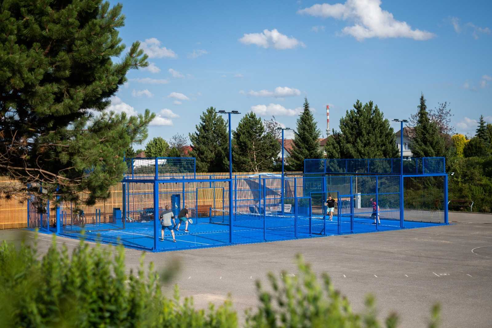 Padelový kurt zasazený do existujícího sportovního areálu během hry