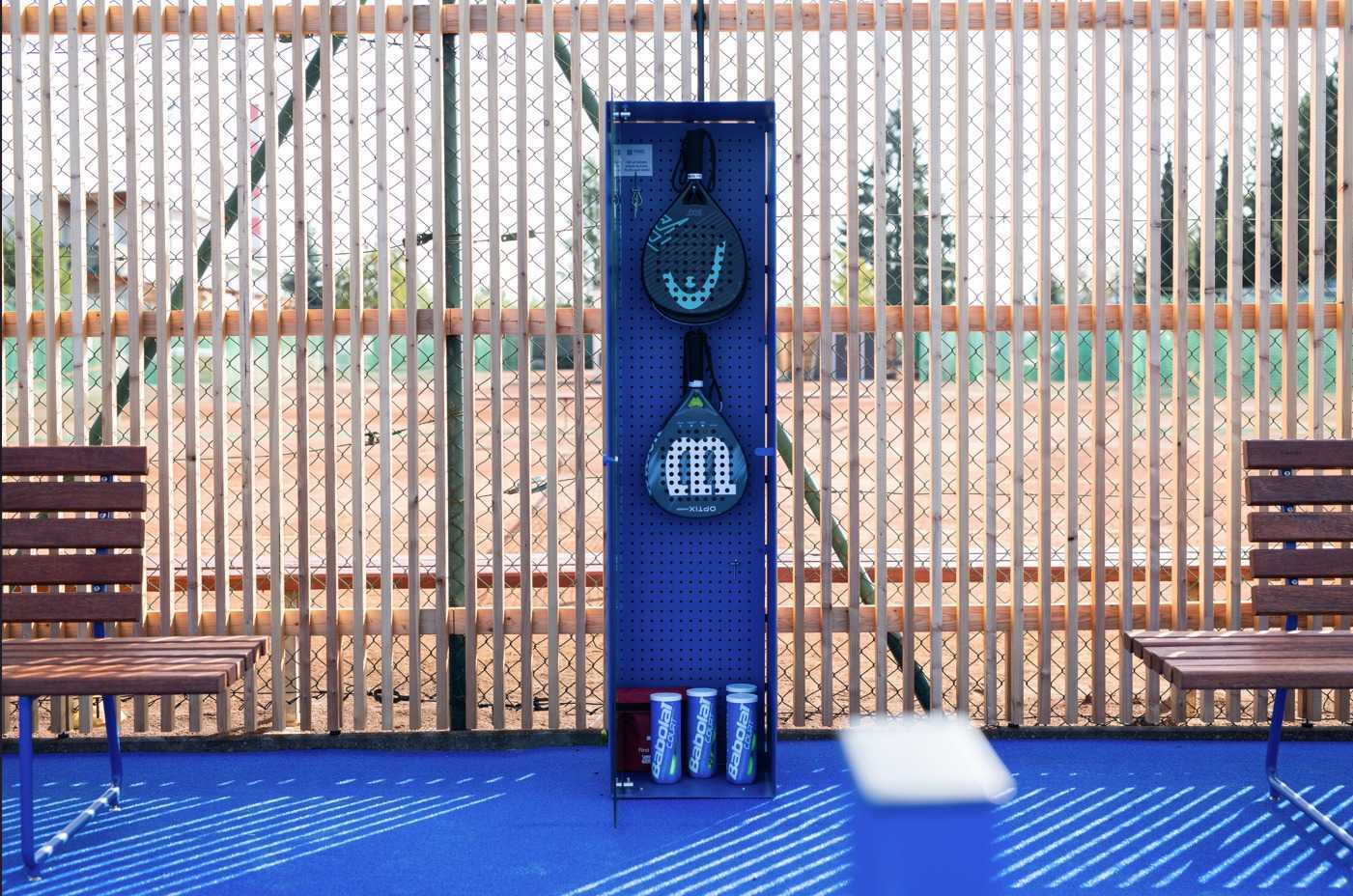 Samoobslužně dostupné padelové rakety a míčky v zázemí kurtu